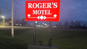 Un letrero rojo para el Motel Roger, con una tipografía sencilla y un símbolo de hoja de arce.