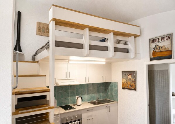 A compact kitchen with a built-in bench, a sink, and a stove.