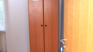 A room with a wooden wardrobe, a radiator, and a door. - Hostel A&A (Novi Sad)