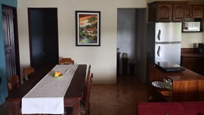 Ein Essbereich mit einem langen Holztisch, Stühlen und einem Bild an der Wand.
