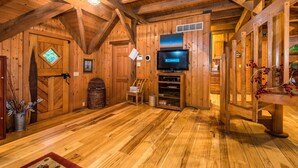 Un interno in legno con televisione, pavimento in legno e camino.