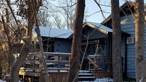 A cabin with a wooden deck and a snow-covered ground. - In Town Nashville Stay | Hot Tub & Walk Everywhere 1BR, 1BA (Nashville)
