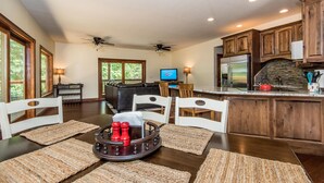 A spacious kitchen with wooden cabinets, a stone backsplash, and a large island. - 100-Acre Private Cabin | Trails, Creek, Pond & Total Seclusion 4BR, 4BA (Nashville)