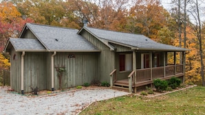 A wooden cabin with a porch and a gravel driveway. - Romantic Cottage for Two | Hot Tub, Fireplace & Near Nashville 1 BR, 1BA (Morgantown)