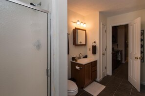 A bathroom with a shower, sink, and toilet.