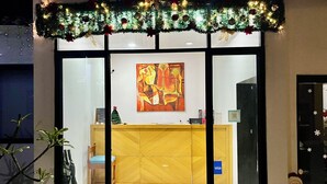 Ein Empfangsbereich mit Holztresen, einem Gemälde an der Wand und einer kleinen Weihnachtstanne.