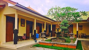 A courtyard with a fountain, seating, and a patterned pavement. - Hotel Sentral (Buleleng)