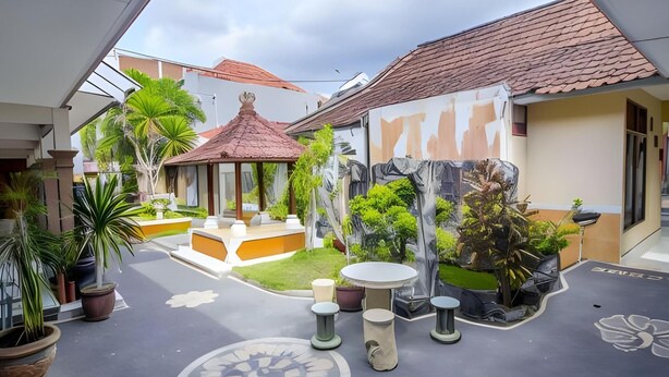 A courtyard with a gazebo, potted plants, and outdoor seating. - Hotel Sentral (Buleleng)