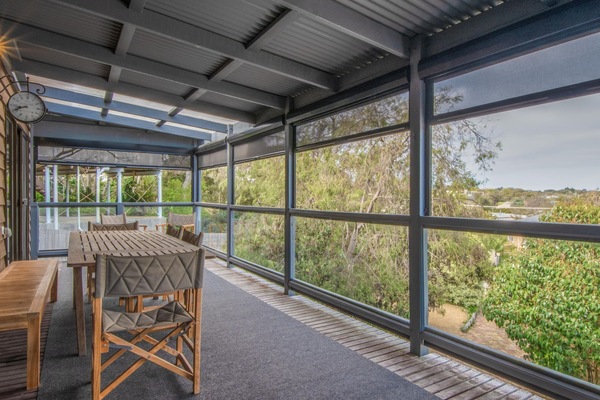 The balcony with dining for 10 people, 2 lounge chairs, Weber BBQ and bar fridge.