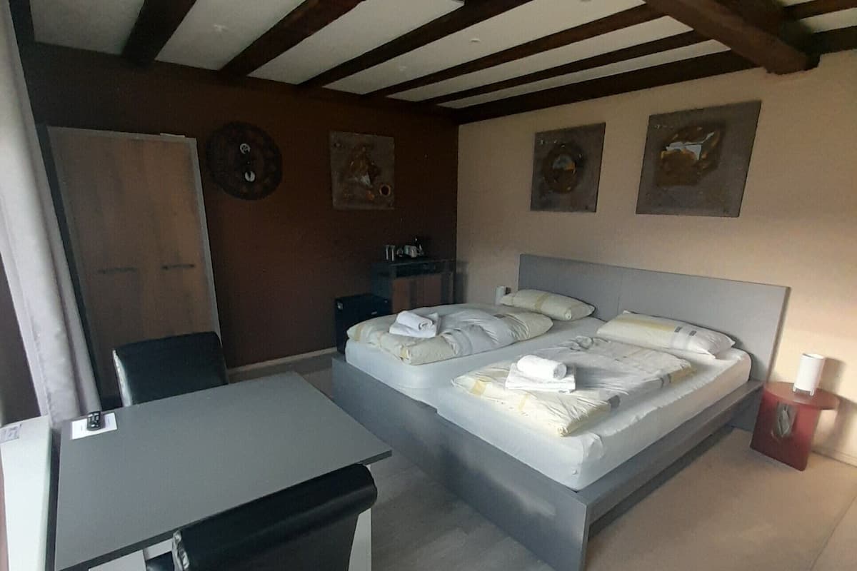 A bedroom with a bed, a desk, and a chair.