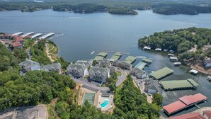 An aerial view of a lakeside property with multiple buildings, a swimming pool, and docked boats. - Emerald Bay 250 - Walk in level 2 bdrm condo (Lake Ozark)