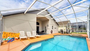 A covered swimming pool with lounge chairs and a sunshade. - 15 Mi to Disney: Home w/ Pool & Lanai in Davenport (Davenport)