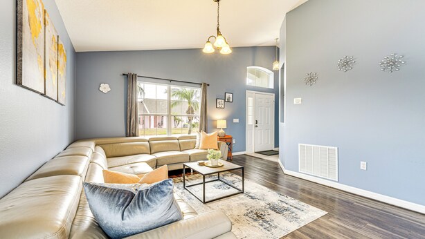 A living room with a sectional sofa, a coffee table, and a large window. - 15 Mi to Disney: Home w/ Pool & Lanai in Davenport (Davenport)