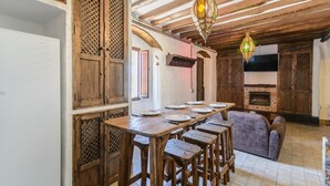 Ein rustikales Interieur mit einem Holztisch, Barhocker und einem Kamin.