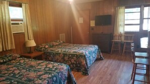 A room with two beds, wooden walls, a ceiling fan, a TV, and a window with curtains. - The Gold Eagle Cabin (Lake George)