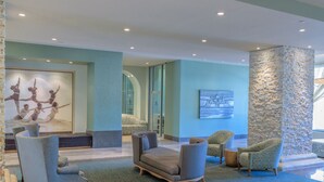 Eine Lobby mit Sitzbereichen, einer Wand aus Stein und Kunstwerken an den Wänden.