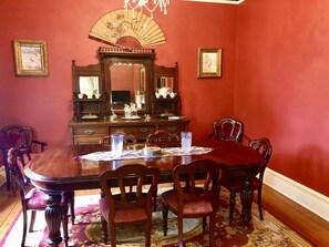 A dining room with a wooden table, chairs, a chandelier, and a fan. - Burnie Brae circa 1908 - Netflix, Wifi, Air Con, Quiet Area, with 2 X Queen Beds (Katoomba)