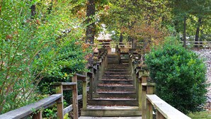 A wooden staircase leading up to a building surrounded by trees and foliage. - Crown Point Resort (Horseshoe Bend)