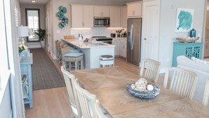 A modern kitchen with white cabinetry, stainless steel appliances, and a central island. - Soothing Spa Haven | Luxe Seaside Escape for 8 (Destin)