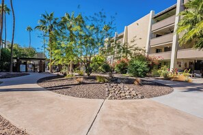 Stunning outdoor space with a circular rock arrangement and lush greenery, surrounded by a multi-story building with balconies.