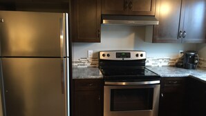 A kitchen with stainless steel appliances, including a refrigerator, oven, and stove. - On TheRock BnB ~ Modern Suite (Comox)