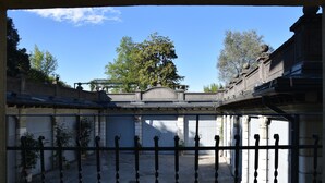 A courtyard with a wrought iron gate, stone walls, and a tree in the background. - Luxury apartment historic center, Air Conditioning, Wi-Fi, Jacuzii, garage.   (Bellagio)