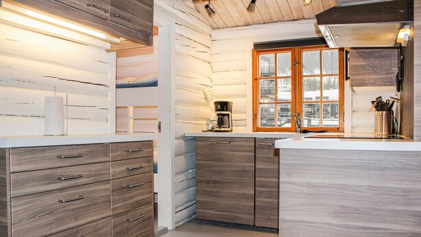 A modern kitchen with wooden cabinetry, a built-in coffee maker, and a window with a view of the city. - Awesome home in Hemsedal with WiFi (Hemsedal)