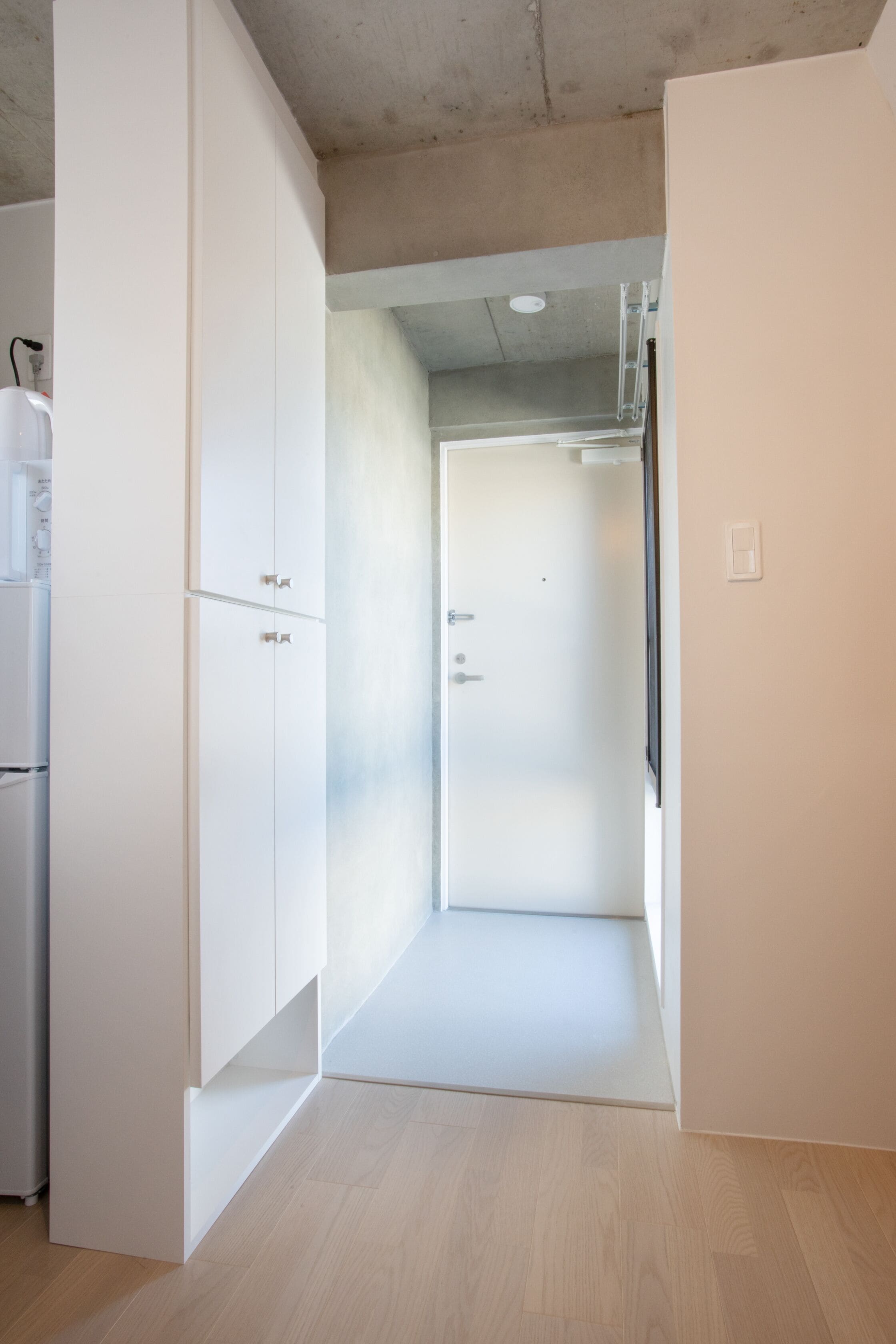 Una habitación moderna y minimalista con muebles blancos y piso de madera.
