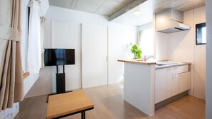 A modern kitchen with white cabinets, a wooden countertop, and a built-in stove. - Laffitte Tokyo WEST (Tokyo)