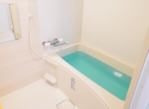 A bathroom with a bathtub, a towel rack, and a toilet.