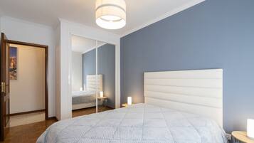 2 habitaciones, escritorio y tabla de planchar con plancha