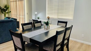 Un coin repas avec une table rectangulaire, six chaises et un globe posé sur la table.