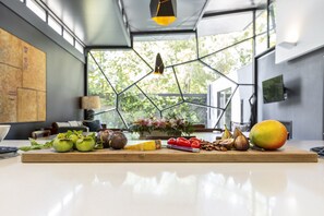 Eine Küchenarbeitsfläche mit frischem Obst und Gemüse und einem Schneidebrett.