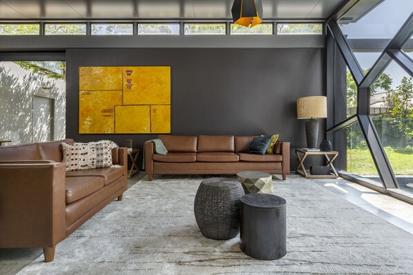 Relax in this stylish living room with a sofa, ottoman, and side table, offering a view of the outdoors.