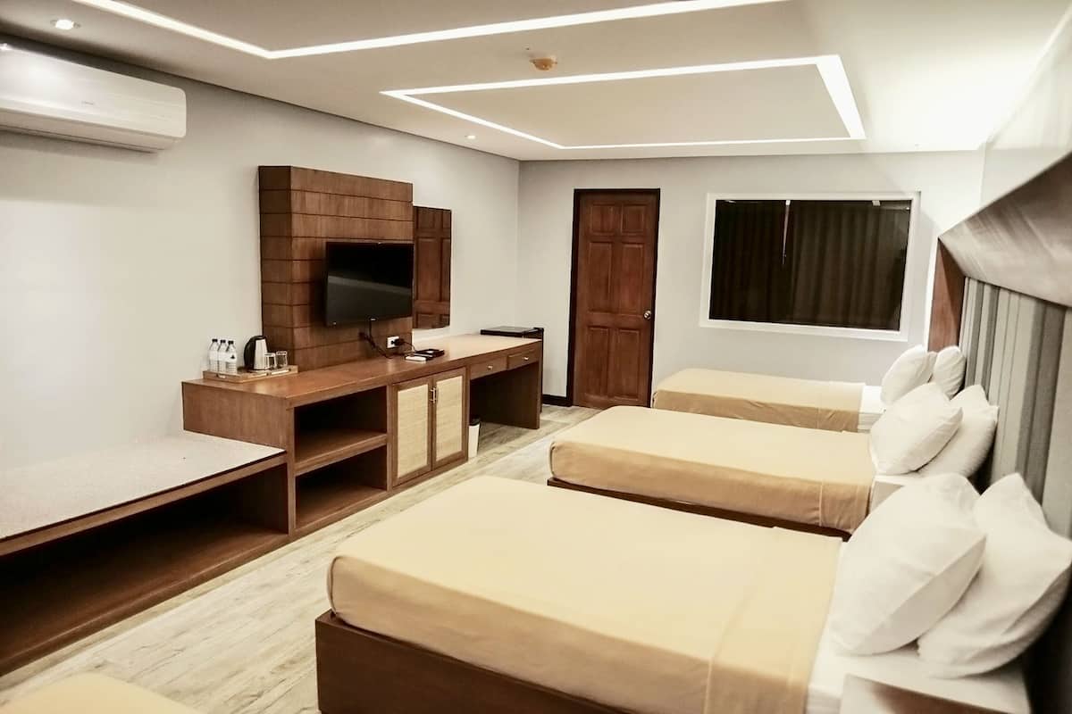 Une chambre d’hôtel avec un bureau en bois, un téléviseur à écran plat, deux lits simples et une grande fenêtre.
