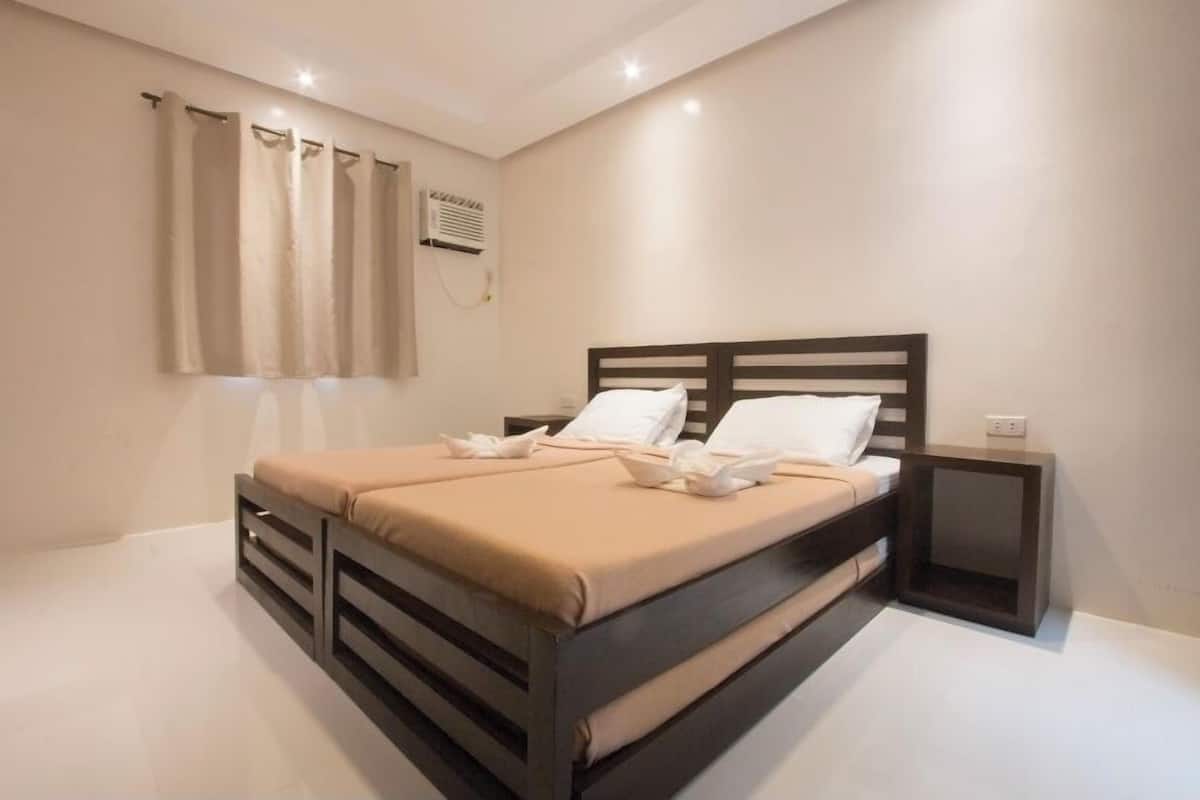 Une chambre à coucher moderne avec un lit, des tables de chevet et des rideaux.