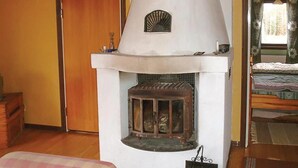 Een kamer met een open haard, een bed en een raam met gordijnen.