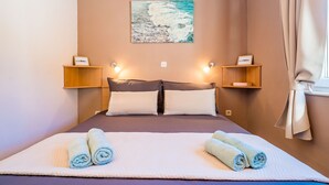 A bedroom with a bed, pillows, a painting, and two bedside tables with lamps. - Apartments Vodnica - One-Bedroom Apartment with Balcony and Partial Sea View (Zaton Mali)