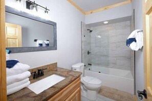 A bathroom with a marble vanity, a glass shower enclosure, and a white toilet. - Daydream Hideaway Cabin - Mtn retreat in the swaying pines, firepit, playground (Pigeon Forge)