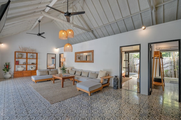 A spacious living area with a large sofa set, a coffee table, and a wooden side table. There are two ceiling fans, a hanging light fixture, and a large mirror on the wall. - 10 Bdr-Last Minute Deal 50%+ OFF!!! Seminyak (Seminyak)