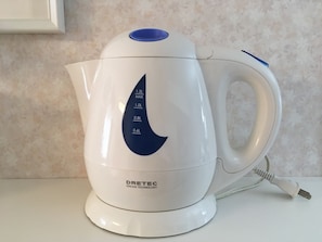 A white electric kettle with a blue handle and a digital display. - Bell Air OKUBO 101 (Tokyo)