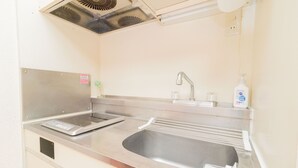 Una cocina de acero inoxidable con un lavamanos, grifo y dispensador de jabón.