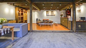 A spacious lobby with a wooden bench, a sofa, and a reception desk.