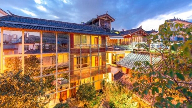 A traditional building with multiple levels and a prominent wooden structure on the roof.
