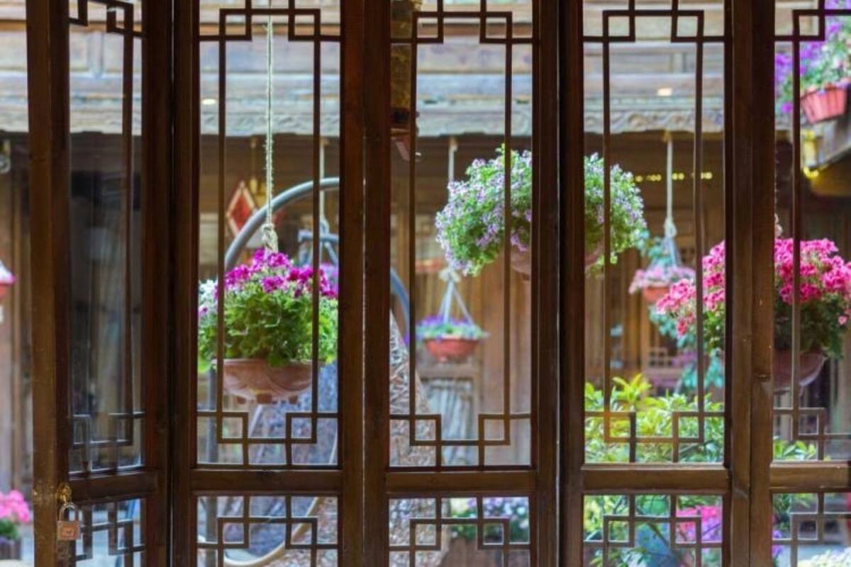 A room with a view of a garden through a wooden lattice door.