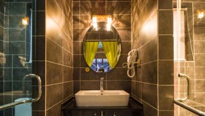 A narrow bathroom with a white sink, a mirror, and a shower. - Flowers without Boundary Inn (Lijiang)
