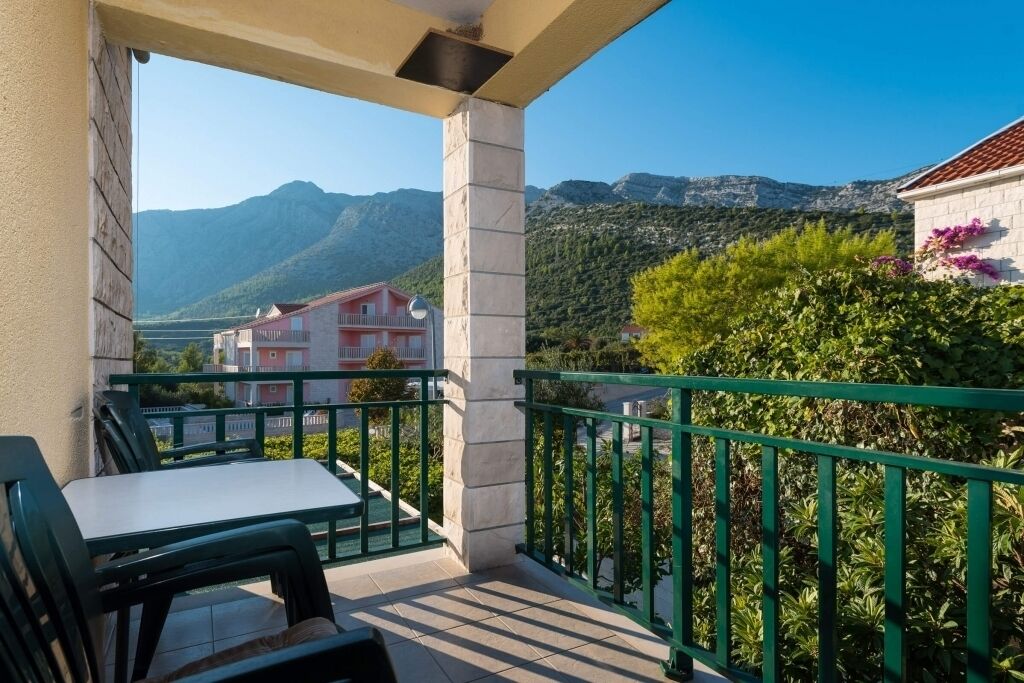 Ein Balkon mit Tisch und Stühlen mit Blick auf eine Berglandschaft.