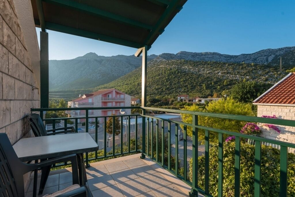 A balcony with a view of mountains and a town.