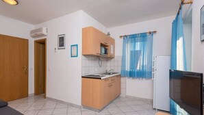 A compact kitchen with a microwave, sink, and wooden cabinets. - Apartment in Orebić with Seaview, Balcony, Air condition, WIFI (4934-7) (Orebic)