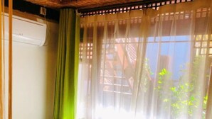 A cozy room with a green sofa, a wooden coffee table, and a vase with flowers.
